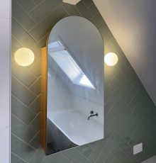High-end oval shaped vanity mirror with two warm lights either side.